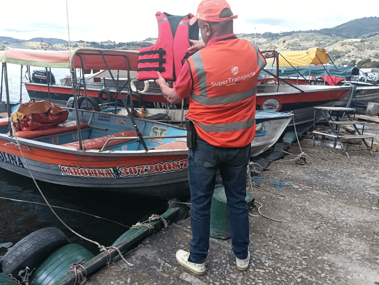 Funcionario de la SuperTransporte inspecciona chalecos salvavidas en embarcaciones fluviales durante jornada de control.