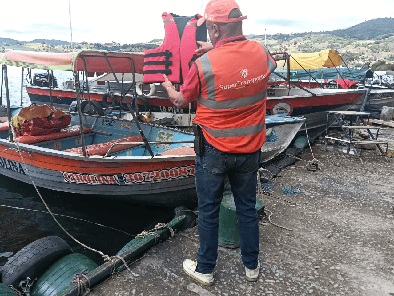 Funcionario de la Superintendencia de Transporte verifica un chaleco salvavidas durante una inspección de seguridad a embarcaciones de transporte fluvial.