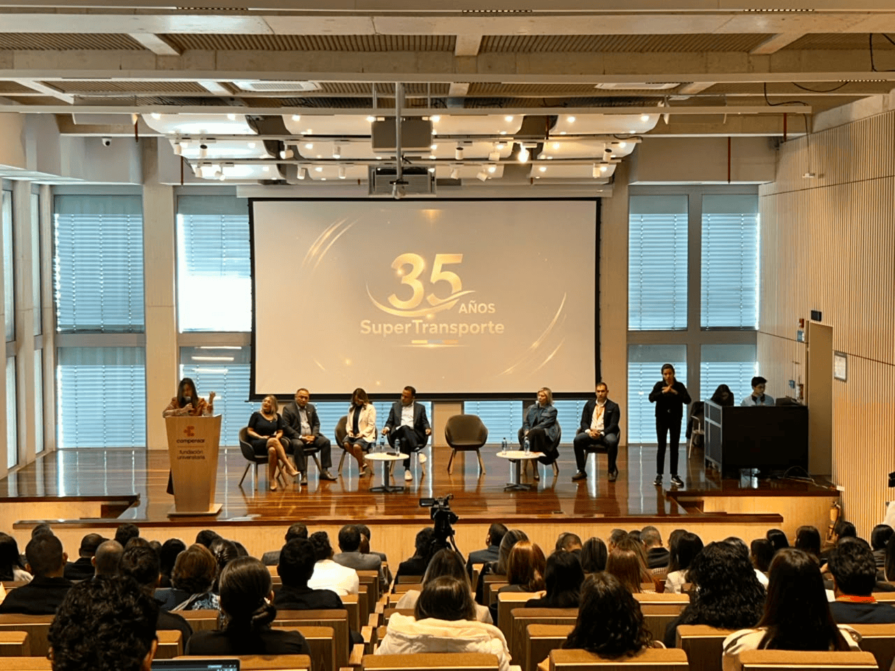 Auditorio con asistentes durante el evento de rendición de cuentas de la Superintendencia de Transporte por sus 35 años, con un panel de directivos en el escenario y servicio de interpretación en lengua de señas.